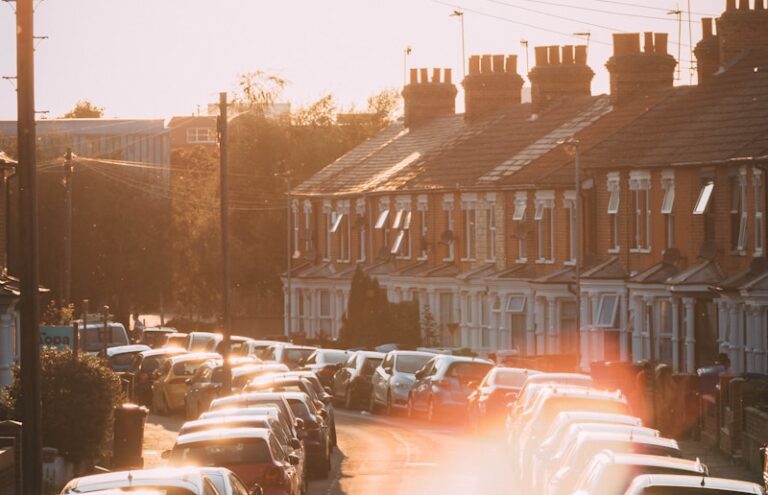 cars parked on street near brown concrete building during daytime