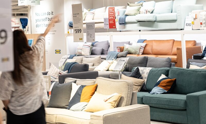 a woman holding a sign in a furniture store